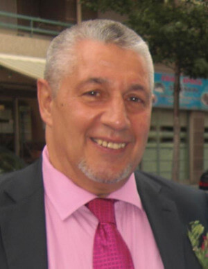 Abd-El-Malik avec une chemise rose et un costume
