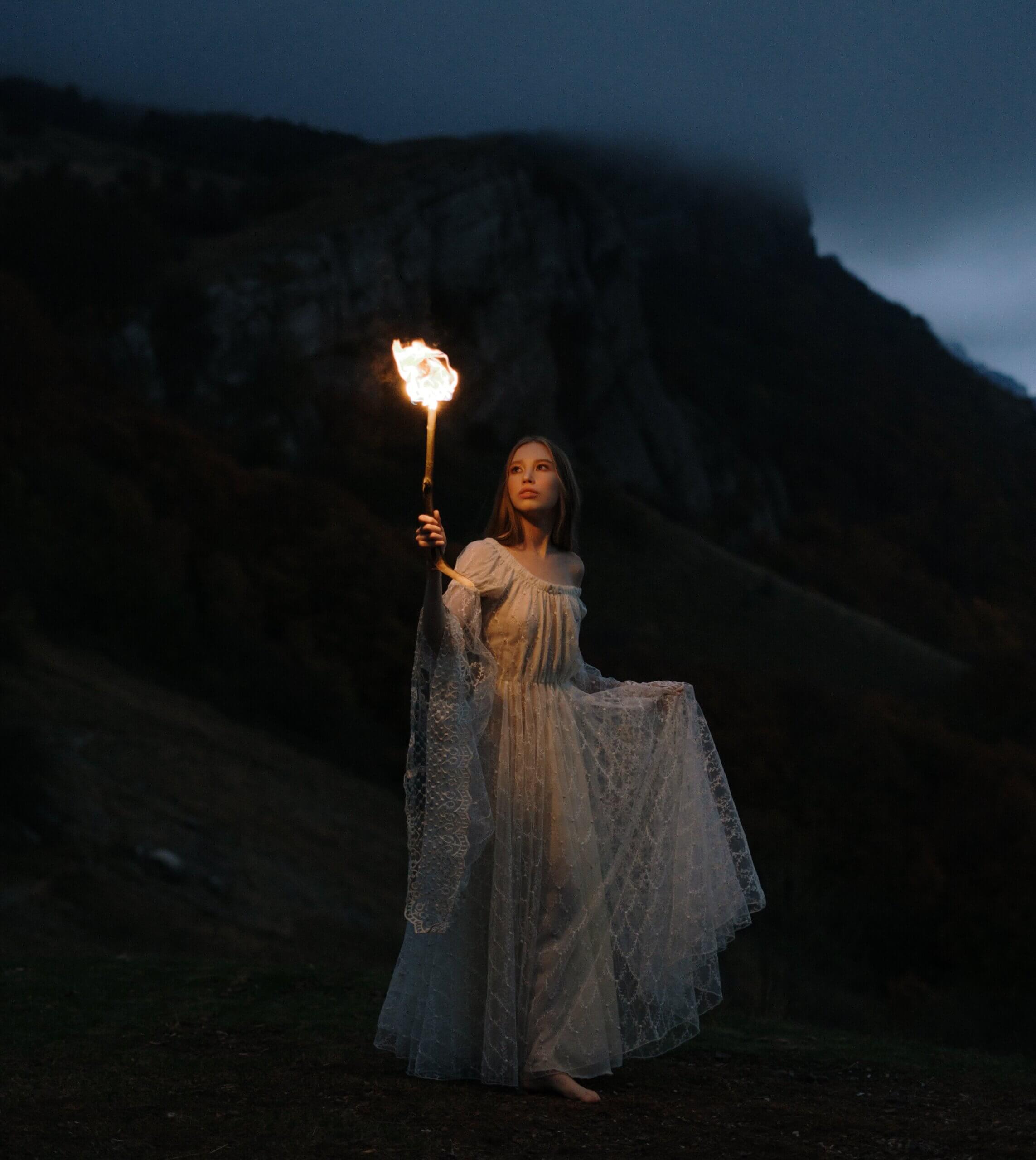 femme tenant une lanterne dans la montagne